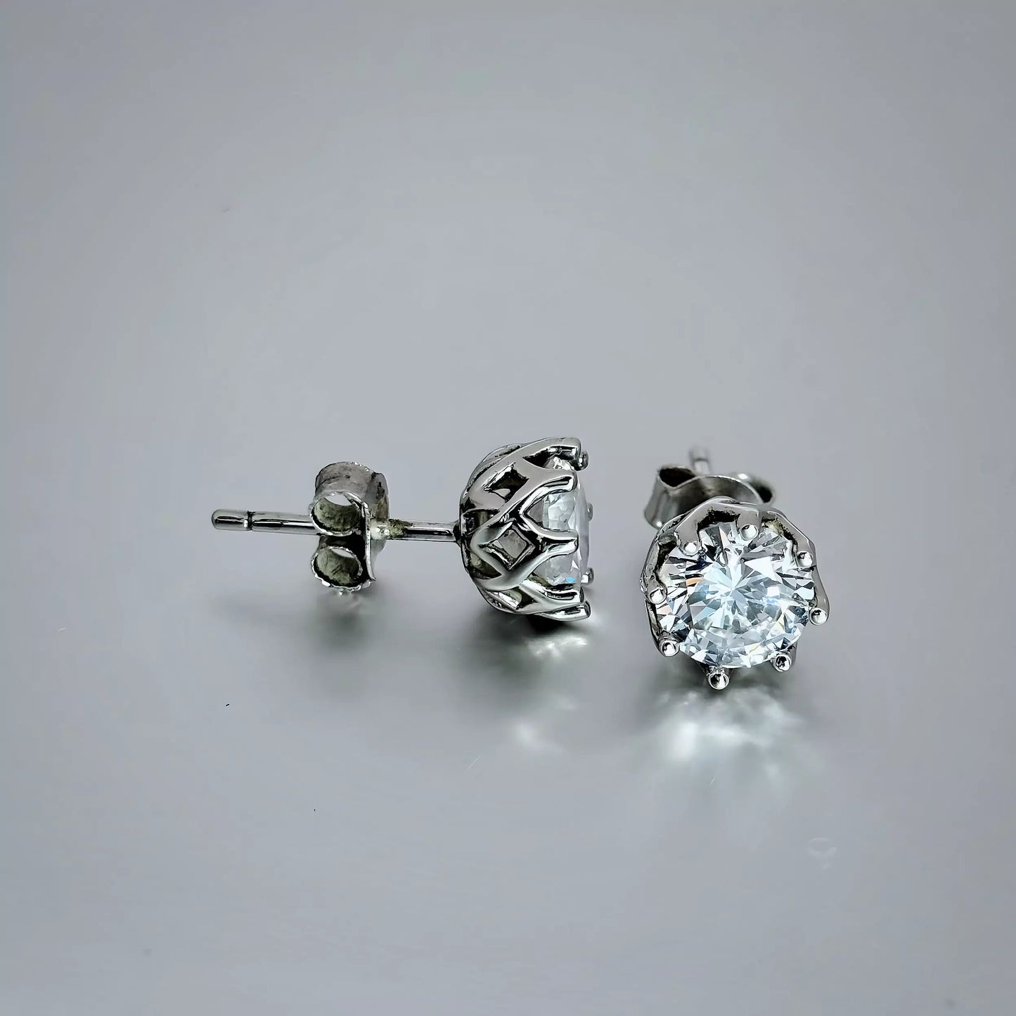 Sterling Silver Cubic Zirconia Stud Earrings. Round Clear Stone, Basket  earring design. , Sterling Silver 925, on a grey background.