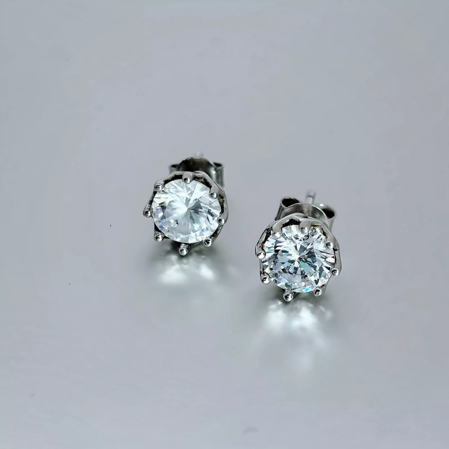 Cubic Zirconia Earrings.  Sterling Silver 925,  round clear stone. Basket  earring design on a grey background.